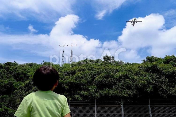 ＜素材＞飛び立った飛行機を見送る男の子 子供,飛行機,空の写真素材