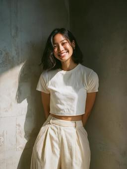 Tシャツとパンツ姿で微笑む、爽やかな女性 Tシャツとパンツ姿で微笑む、爽やかな女性の写真