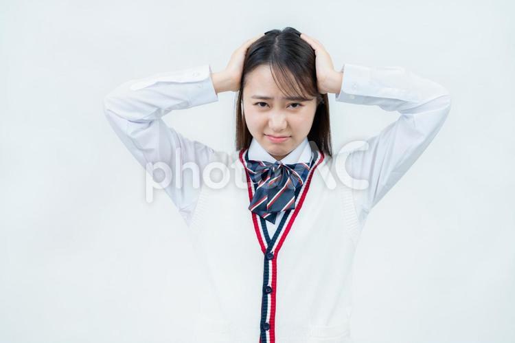 頭を抱えて悩む女子高校生 女子高生,高校生,悩むの写真素材
