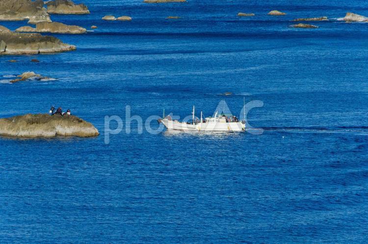 青い海に浮かぶ漁船と岩礁 漁船,海,岩礁の写真素材