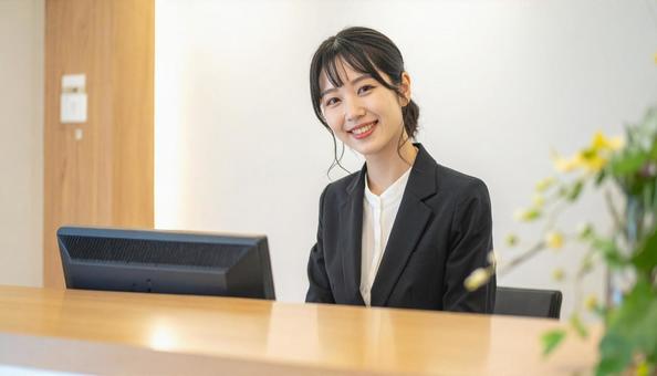 笑顔で対応する女性の受付嬢 笑顔で対応する女性の受付嬢の写真
