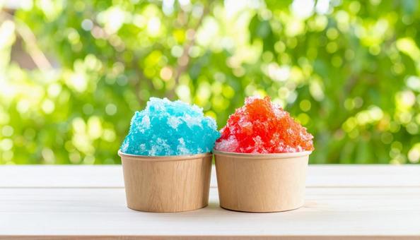 赤いイチゴシロップと青いシロップのかき氷の写真