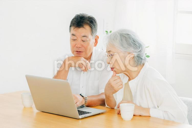 ノートパソコンを見る高齢者夫婦（困る） 高齢者,パソコン,困るの写真素材