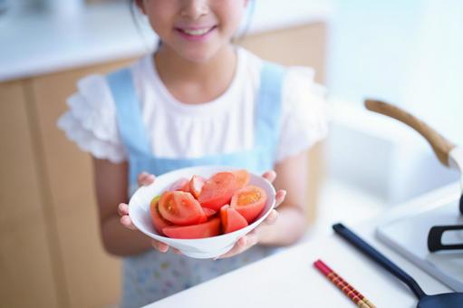 ボウルいっぱいのトマトを両手に持つ子供 女の子,トマト,野菜の写真素材