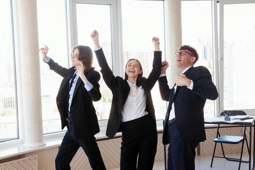 窓際でノリノリなスーツの男女 男女,外国人,ガッツポーズの写真素材