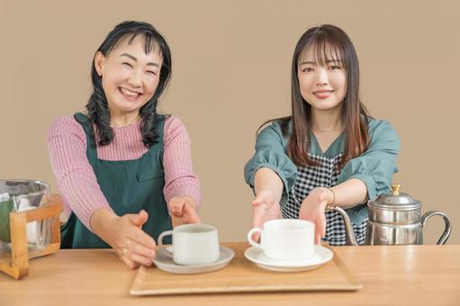 カフェで珈琲を出す2人 カフェで珈琲を出す2人 カフェ,笑顔,エプロンの写真素材