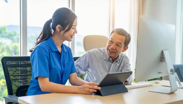 ケアマネジャーに相談するシニアの男性の写真