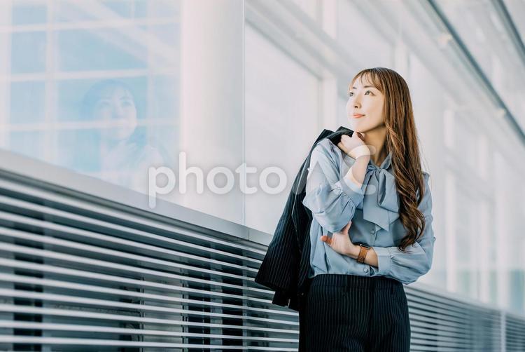 窓の外を見て微笑む女性ビジネスマン 女性,ビジネス,ビジネスウーマンの写真素材