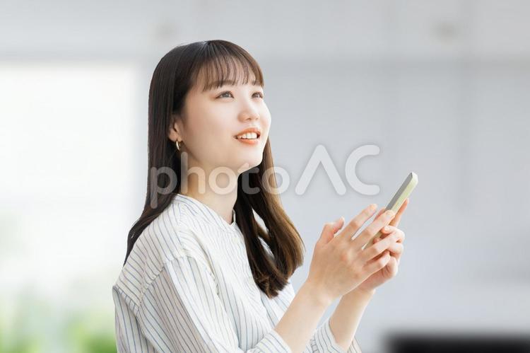 スマホを操作をする若いビジネスウーマン 女性,ビジネス,ビジネスウーマンの写真素材