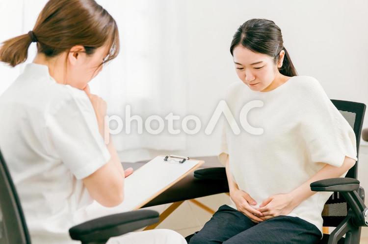 病院に来た女性（腹痛） 腹痛,病院,診察の写真素材