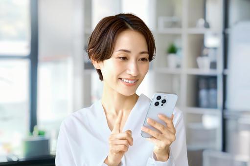 携帯電話を使うビジネスウーマン スマホ 携帯電話を使うビジネスウーマン スマホ ビジネスウーマン,スマホ,オフィスの写真素材