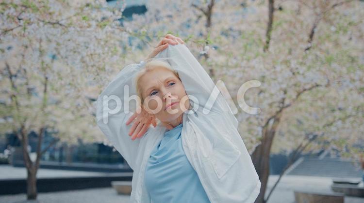 桜の前で肘を伸ばす女性 女性,人物,元気の写真素材