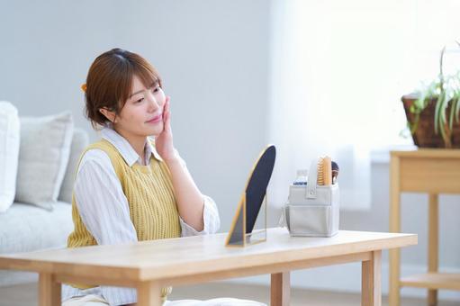 鏡を見ながら微笑み頬を触る女性 女性,微笑む,頬の写真素材