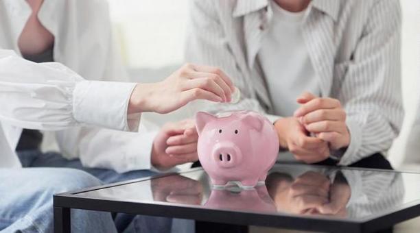 貯金箱にお金を入れるアジア人のカップル 貯金,カップル,女性の写真素材