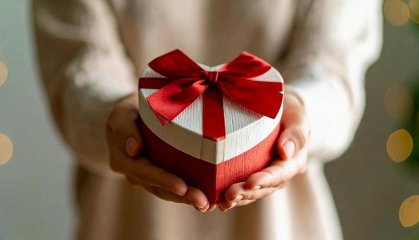 白い箱のプレゼントを両手に取る女性の手 白い箱のプレゼントを両手に取る女性の手の写真