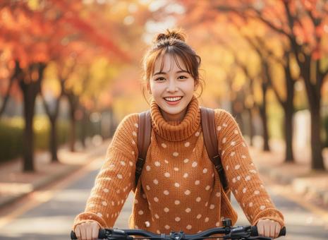秋の紅葉を背景に自転車にのる女性 秋の紅葉を背景に自転車にのる女性の写真
