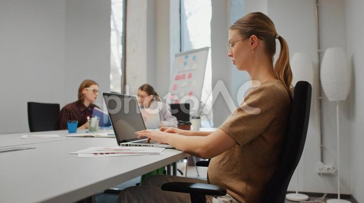 オフィスでノートパソコンを使う妊娠中の女性と同僚 ビジネス,ビジネスマン,ビジネスウーマンの写真素材