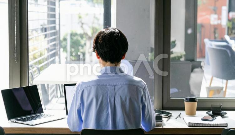 カフェで仕事をするフリーランス男性 男性,コワーキングスペース,コワーキングの写真素材