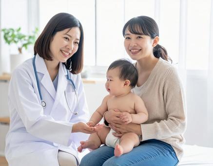 赤ちゃん定期健診をする女性医師と母親の写真