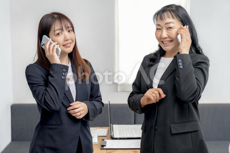 スマホと二人のビジネスウーマン ビジネス,女性,ビジネスマンの写真素材