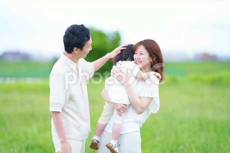 女の子を抱っこする女性と撫でる男性 女性,男性,女の子の写真素材