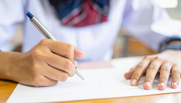 ノートに記入する日本人中学生の女の子の手 ノートに記入する日本人中学生の女の子の手の写真