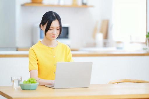 真剣な顔でパソコン作業をする女性の写真