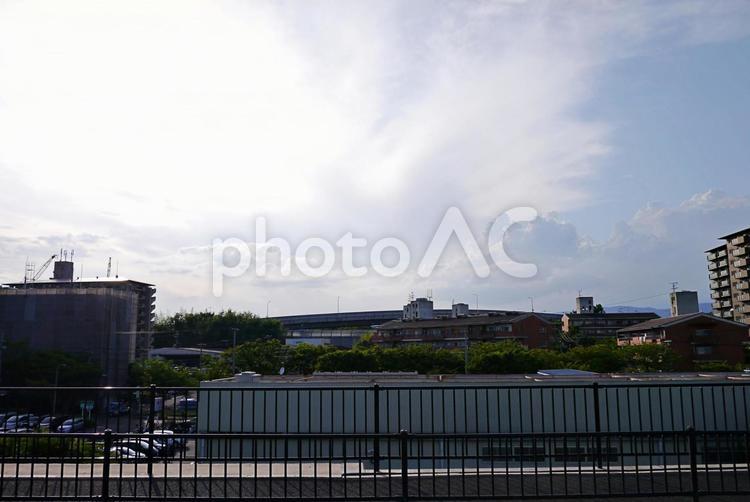 雲ごしでも眩しい太陽と夏の町並み 陽光,陽射し,夏雲の写真素材
