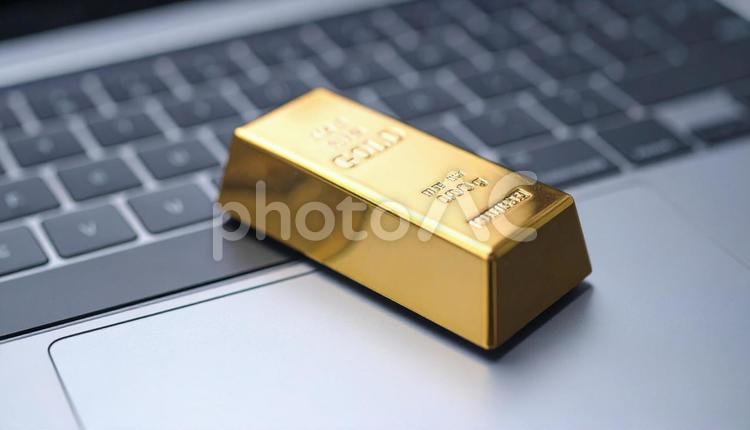 パソコンに置かれた金の延べ棒のミニチュア 金,ゴールド,先物の写真素材
