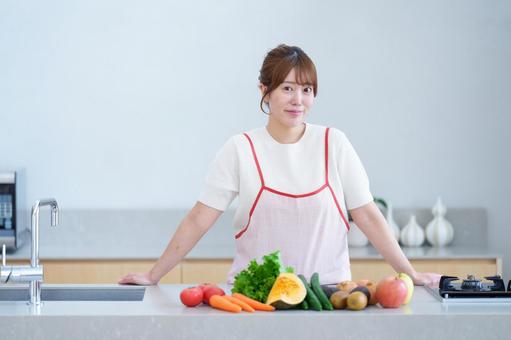 採れたての野菜とカメラ目線の女性 女性,微笑む,エプロンの写真素材