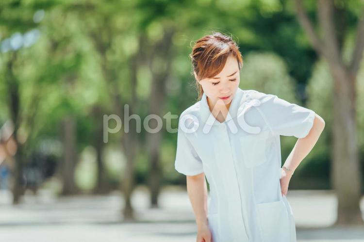 体調不良の白衣の女性 腰痛,痛い,腰の写真素材