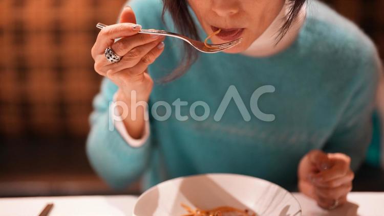 食事をする青いセーターの女性 女性,食事中,青いセーターの写真素材