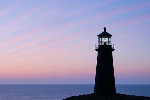 夕暮れの海に立つ灯台シルエット 夕暮れの海に立つ灯台シルエットの写真