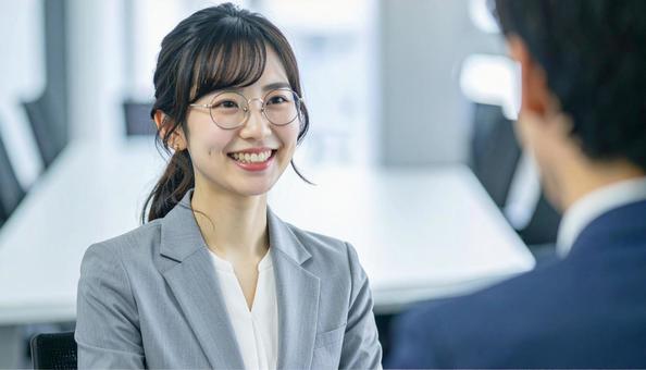 笑顔で話すスーツ姿の女性 笑顔で話すスーツ姿の女性の写真