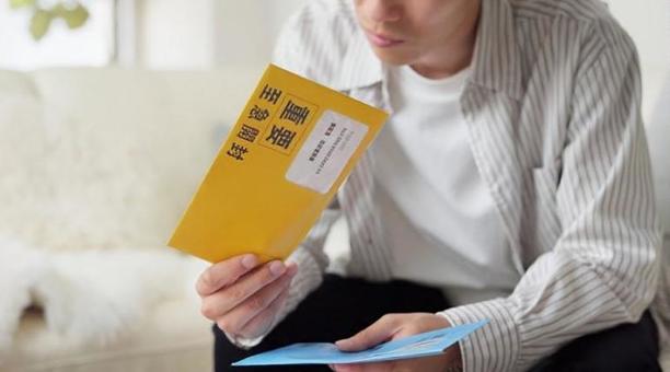 督促状を確認するアジア人男性 督促状,催促,封筒の写真素材