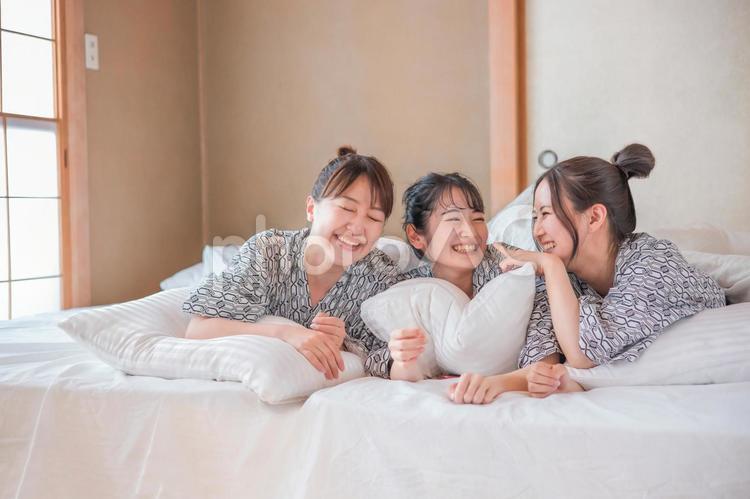 女子旅・布団でくつろぐ女性たち（相談） 女子旅,宿泊,浴衣の写真素材