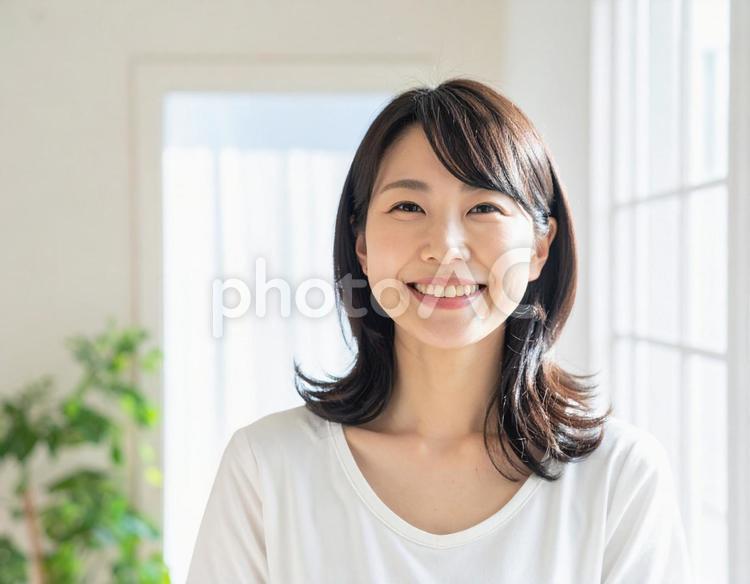 室内で微笑む30代の女性 女性,室内,白背景の写真素材