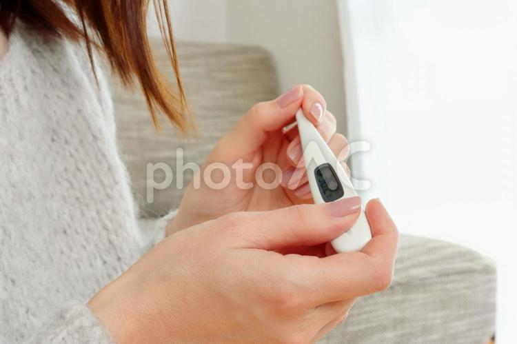 体温計を持つ女性の手 体温計,検温,熱の写真素材