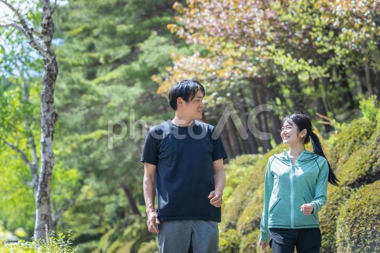 緑の中でトレーニングする男女　　 ウォーキング,歩く,ランニングの写真素材