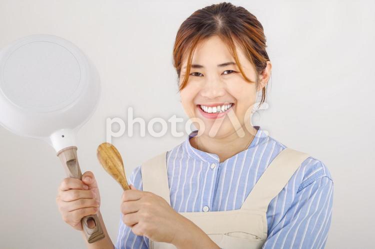 調理器具を持つ元気な女性のイメージ 料理,笑顔,笑うの写真素材