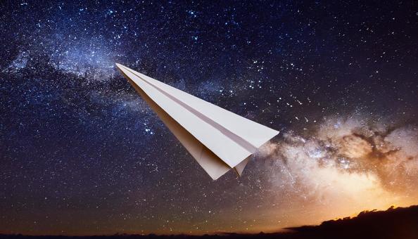 宇宙に向かって飛んでいる紙飛行機 宇宙に向かって飛んでいる紙飛行機の写真