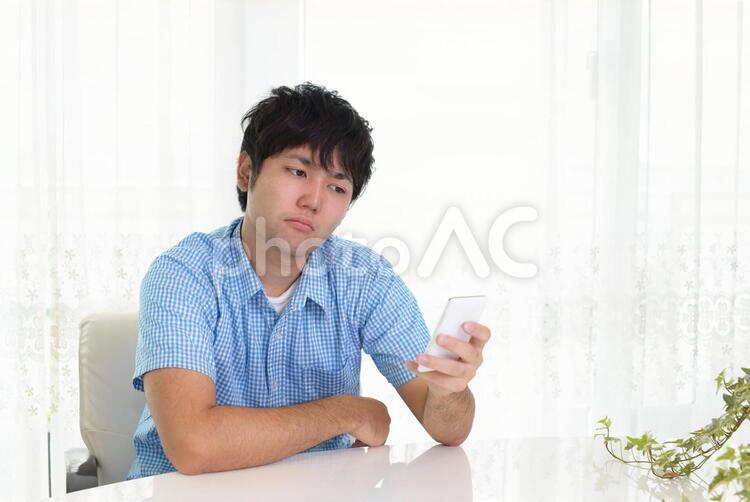 憂鬱な表情の男性 男性,男,スマートフォンの写真素材