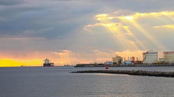 夕焼けの中を出港する貨物船 貨物船,工業地帯,夕暮れの写真素材