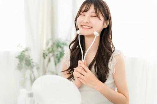 美顔ローラーを使ってマッサージする女性 美顔ローラーを使ってマッサージする女性 美顔ローラー,マッサージ,ホームケアの写真素材