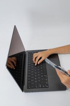 ノートPCとスマートフォンでマルチタスク ノートパソコン,スマートフォン,手の写真素材