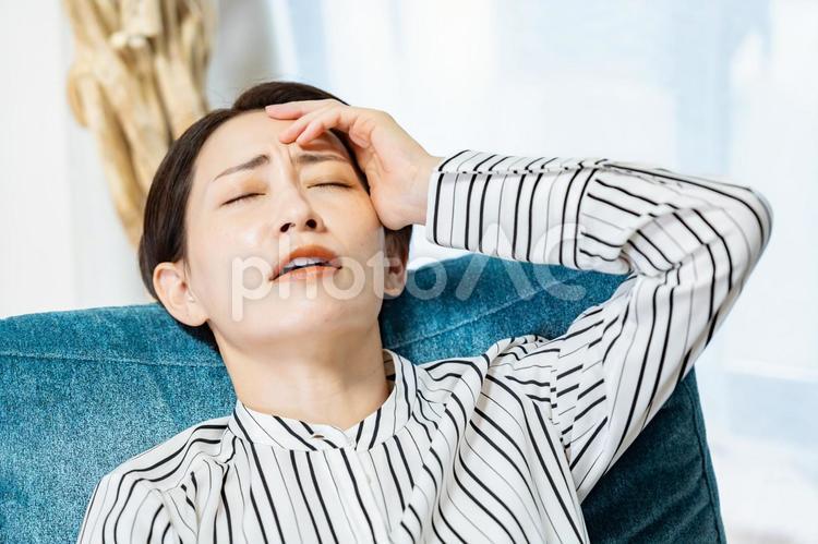 ソファに項垂れる女性 女性,ミドル,心配の写真素材