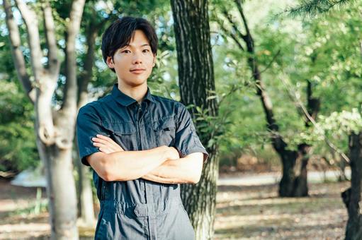 作業着を着た男性が腕を組む 作業服男性,森林,森の写真素材