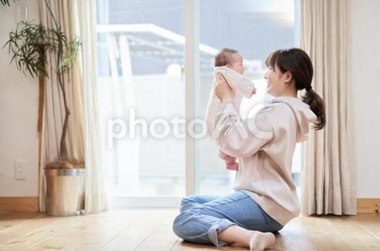 リビングで赤ちゃんを抱えるお母さん 赤ちゃん,抱っこ,抱えるの写真素材