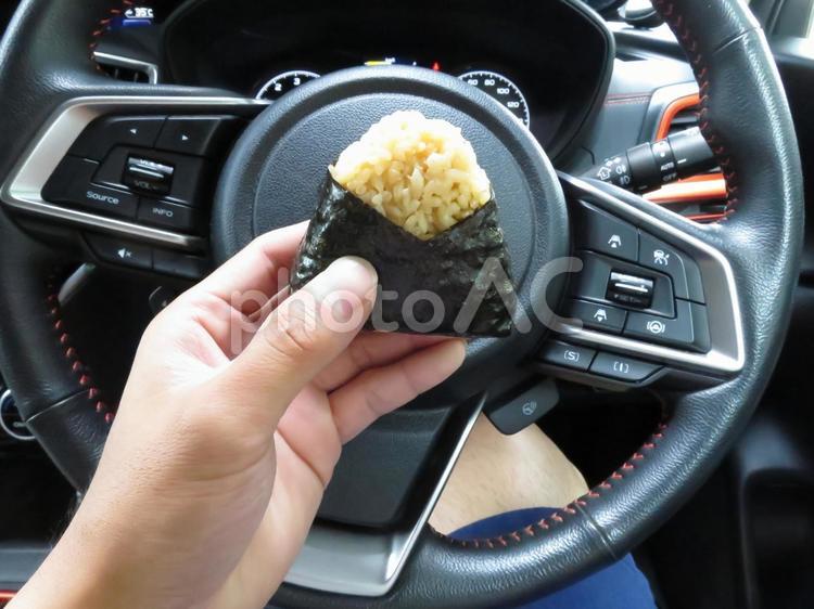 休憩中の車内でおにぎりを食べる2 車内,おにぎり,海苔の写真素材