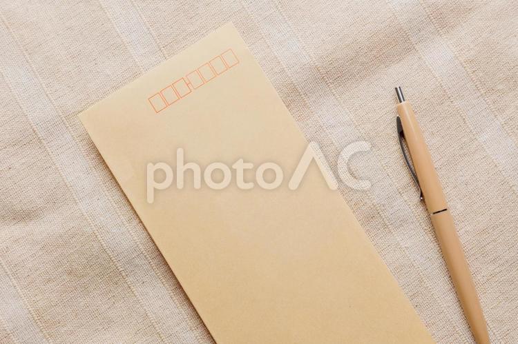 机に置かれた茶封筒とペン 封筒,手紙,紙の写真素材